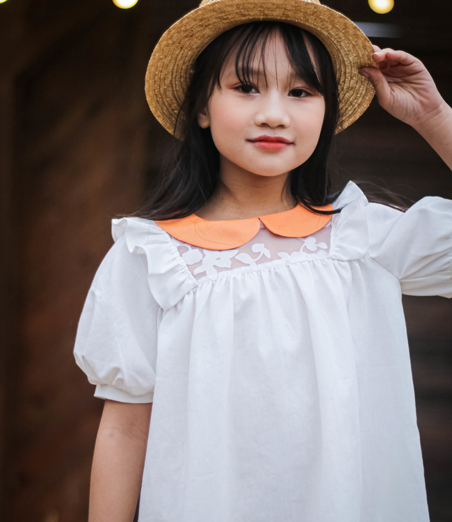 Váy trắng cổ cam phối ngực hoa